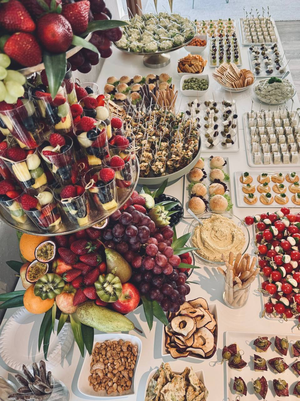 Reichhaltiges Fingerfood-Buffet mit Früchteetagere, Häppchen und Gläsern